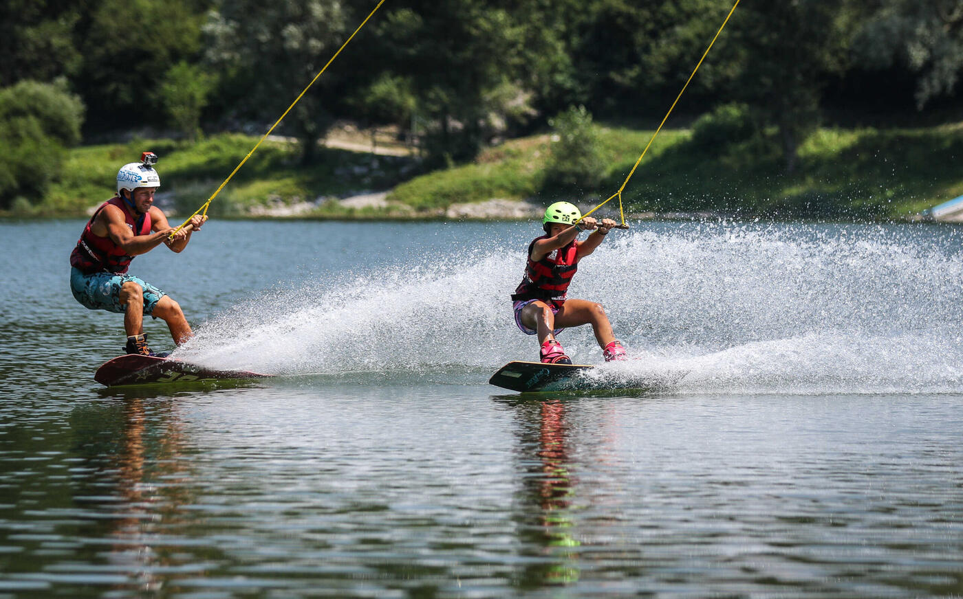 Due rider sul cavo, uno dietro l'altro, in mezzo al lago