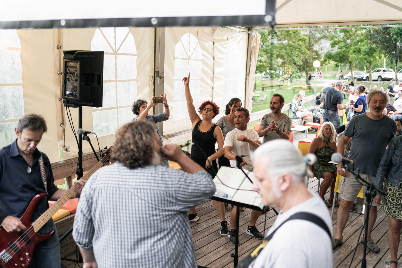 Una band suona dal vivo sotto il gazebo, con la gente ai tavoli intorno
